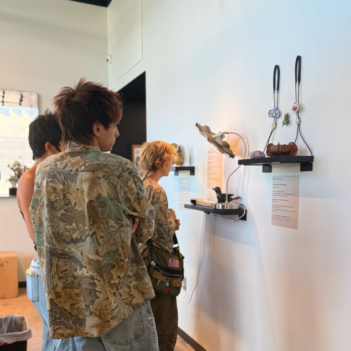 Visitors looking at ceramic pieces on gallery shelves