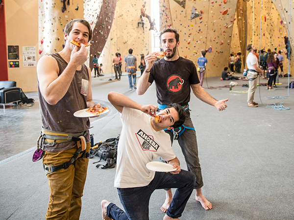 Friends eat pizza at an indoor climbing gym